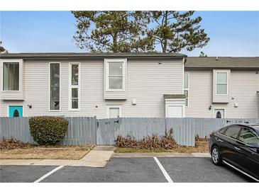 Exterior view of townhouse with gray siding, fenced yard, and parking at 257 Country Club Dr, Jonesboro, GA 30238