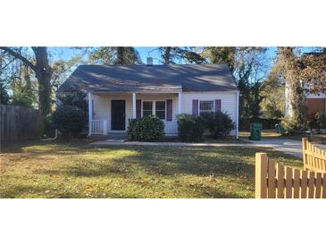 Charming one-story house with a well-manicured lawn and wooden fence at 1809 Ellington St, Decatur, GA 30032