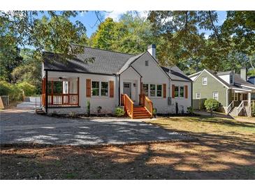 Charming renovated home with a white brick exterior, wood accents, and a landscaped yard at 985 Columbia Dr, Decatur, GA 30030