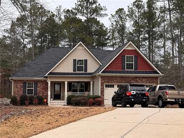 Two-story house with brick and siding, a covered porch, and a two-car garage at 5511 E Stoneway Ct, Villa Rica, GA 30180