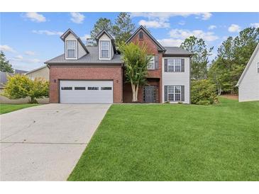 Brick two-story house with a large front yard and attached garage at 2617 Spring Cast Dr, Buford, GA 30519