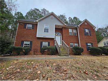 Brick two-story house with a landscaped yard and attached stairs at 4671 W Lake Se Dr, Conyers, GA 30094