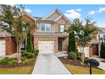 Brick townhouse exterior with a two-car garage and landscaped front yard at 3192 Haynes Park Dr, Lithonia, GA 30038