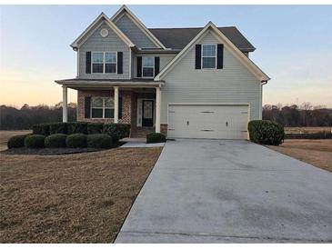 Two-story house with gray siding, brick accents, and a large driveway at 1241 St James Pl, Loganville, GA 30052