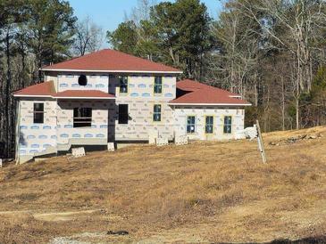 Two-story house under construction, red roof, and large windows at 515 Penny Ln, Loganville, GA 30052