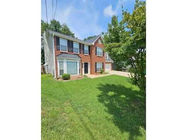 Two-story brick home with a spacious lawn and attached garage at 3987 Cameron Close, Ellenwood, GA 30294