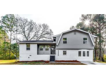 Newly renovated house featuring gray siding, white brick, and a landscaped yard at 6685 Buckhurst Trl, Atlanta, GA 30349