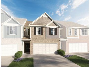 Two-story townhome with brick and siding exterior, two-car garage, and landscaping at 713 Cygnet Ln, Grayson, GA 30017