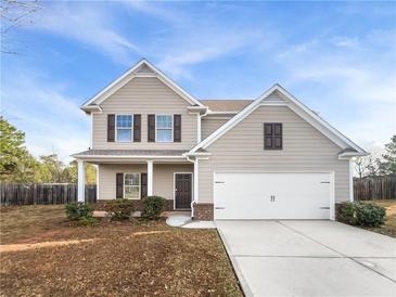 Two-story house with tan siding, brown shutters, and a two-car garage at 3441 Sandstone Se Trl, Conyers, GA 30013