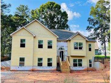 Newly constructed two-story house featuring a charming yellow exterior and a welcoming front porch at 5995 Crowley Dr, Douglasville, GA 30135