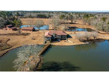 Aerial view of a house on a lake with a bridge and other buildings on the property at 7108 Villa Rica Hwy, Dallas, GA 30157