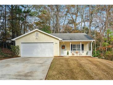 Cute yellow house with a 2-car garage and front porch at 5862 Homestead Cir, Rex, GA 30273
