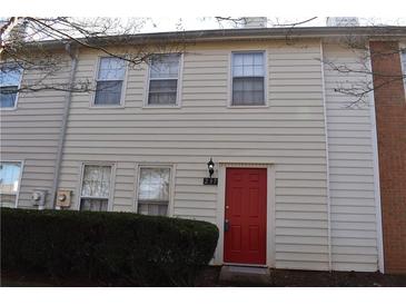Tan two-story townhouse with red front door and landscaping at 237 Chads Ford Way, Roswell, GA 30076