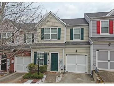 Tan townhome with green shutters, white garage doors, and landscaping at 230 Valley Xing, Canton, GA 30114