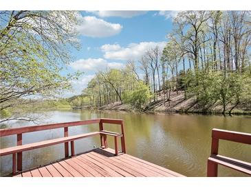 Serene waterfront view from a private red wooden dock at 8145 Stone Hill Rd, Cumming, GA 30028