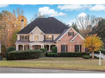 Brick two-story house with a large front porch and landscaping at 500 Poplar Creek Xing, Canton, GA 30114