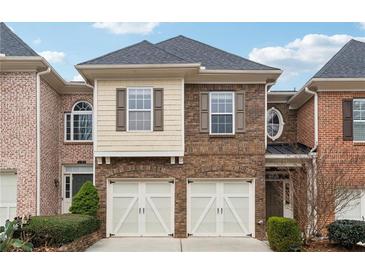Brick front exterior of a two-story townhome with a two-car garage at 2368 Harshaw Ave # 166, Lawrenceville, GA 30043