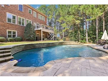 Inviting in-ground pool with stone coping and spacious patio at 3950 Stanford Dr, Cumming, GA 30041