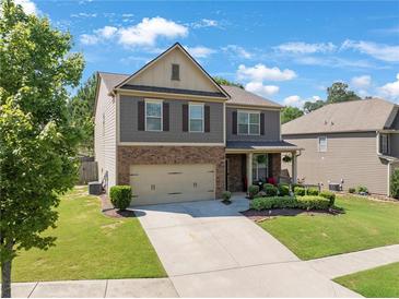 Two-story home with a brick and siding exterior, two-car garage, and landscaped front yard at 1252 Thomas Daniel Way, Lawrenceville, GA 30045