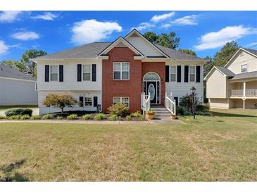 Brick and siding house with a landscaped lawn and large windows at 815 Windy Mill Ct, Temple, GA 30179