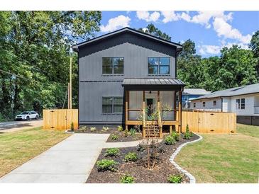 Modern two-story home with gray siding, metal roof, and landscaped yard at 1129 Victory Sw Dr, Atlanta, GA 30310