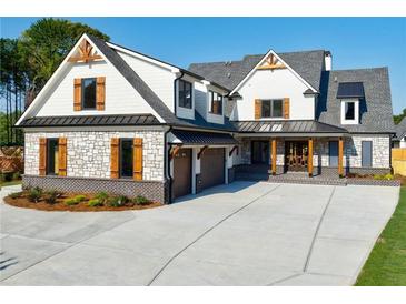 Two-story home with stone accents and a three-car garage at 1106 Flowers Dr, Cumming, GA 30041