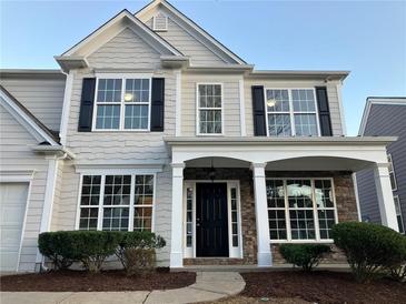 Two-story house with gray siding, stone accents, and a covered porch at 681 Courageous Ct, Lawrenceville, GA 30043