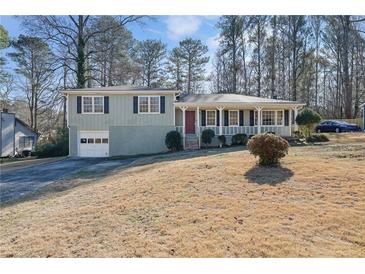 Ranch style home with a green exterior, attached garage, and a covered porch at 1216 Pine Creek Dr, Woodstock, GA 30188