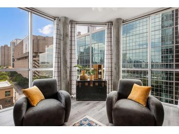 Spacious living room with floor to ceiling windows and city views at 285 Centennial Olympic Park Nw Dr # 1108, Atlanta, GA 30313