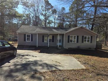 Ranch style house with a carport and mature trees in the yard at 4478 Nebo Rd, Hiram, GA 30141