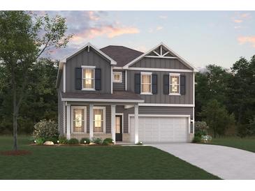 Two-story house featuring gray siding, a white garage door, and landscaping at 2422 Brown Dove Way, Grayson, GA 30017