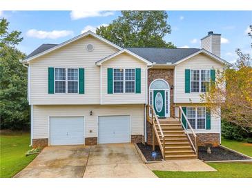 Two-story house with a stone facade, green shutters, and a two-car garage at 1216 Bradford Park Ln, Auburn, GA 30011