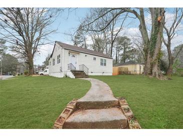 Cute bungalow with a landscaped lawn and walkway at 1288 Almont Sw Dr, Atlanta, GA 30310