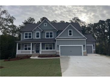 Two story house with gray siding, white trim, and a three-car garage at 1081 Hawthorn Ct, Loganville, GA 30052