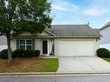 Beige house with attached garage, landscaping, and driveway at 98 Hill Side Way, Hiram, GA 30141