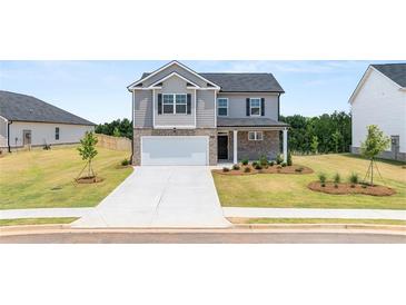 Two-story home with brick and siding, attached garage, and landscaping at 532 Vervain Drive, Locust Grove, GA 30248