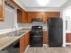 Galley-style kitchen with wood cabinets and black appliances at 874 Ohara Dr, Jonesboro, GA 30236