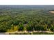 Aerial view of a house nestled in a large wooded lot near a road at 557 Veterans Pkwy, Fayetteville, GA 30214