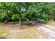 Gravel driveway leading into a wooded area with a grassy field at 1042 Harbins Rd, Dacula, GA 30019