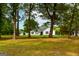 White house partially visible through lush green trees at 1042 Harbins Rd, Dacula, GA 30019