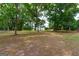 White house partially visible through lush green trees at 1042 Harbins Rd, Dacula, GA 30019