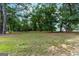 Large grassy area with mature trees and a home visible in the background at 1042 Harbins Rd, Dacula, GA 30019