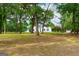 White house partially visible through lush green trees at 1042 Harbins Rd, Dacula, GA 30019
