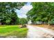 Gated entrance to a property with a long driveway and lush landscaping at 1042 Harbins Rd, Dacula, GA 30019