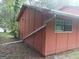 Side view of a red house with gutters and landscaping at 7396 Meadows Dr, Riverdale, GA 30274