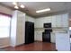Galley style kitchen with white cabinets, black appliances, and hardwood floors at 110 Emily Park, Fayetteville, GA 30215