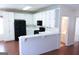 White kitchen cabinets, black appliances, breakfast bar, and view into bathroom at 110 Emily Park, Fayetteville, GA 30215