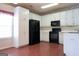 White kitchen cabinets, black appliances, and hardwood floors at 110 Emily Park, Fayetteville, GA 30215