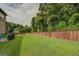 Fenced backyard with green grass and trees at 445 Brickstone Way, Covington, GA 30016