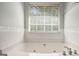 Bathroom with a jetted tub and window at 132 Sunflower Meadows Dr, Mcdonough, GA 30252